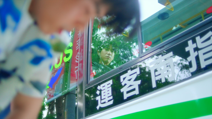 嘟嘟 (Dudd) watches a young man puking from inside of a bus in Jade's 苦力怕 Creeper music video