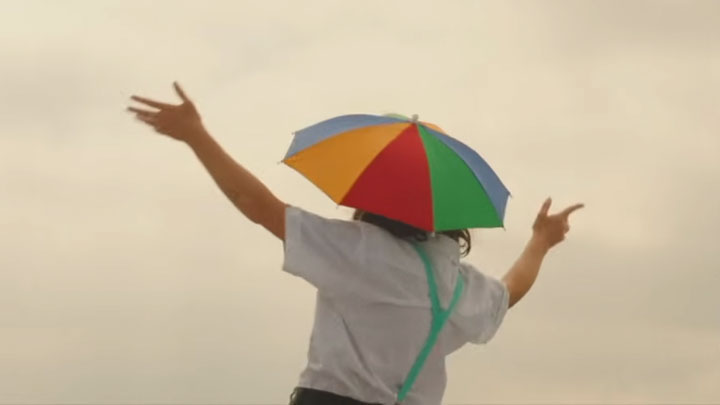 Kal Traver wears an umbrella hat in a music video for a Rubblebucket song called Geometry